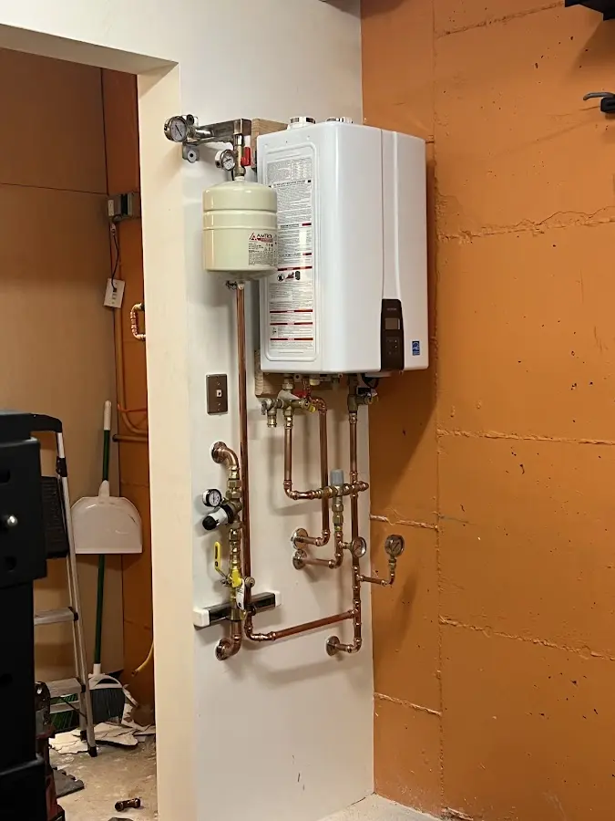Plumbing technician inspecting water heater connections in Highfill